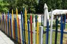 Blick über den Zaun - der aus überdimensional großen Buntstiften besteht - in den Kindergarten von Winhöring.