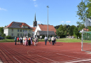 Gebäude mit Photovoltaikelementen auf den Dächern umrahmen einen Sportplatz mit  einem Kunststoffbelag